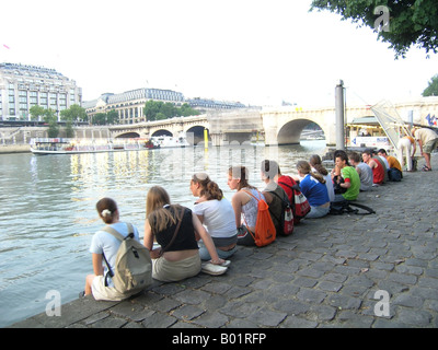 Groupe scolaire en attente sur Seine River Bank près de Pont Neuf avant une visite en bateau Banque D'Images