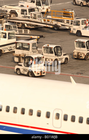 Avion de ligne à l'aéroport services au sol et l'avion remorqueur tracteur chariot à bagages des véhicules Banque D'Images