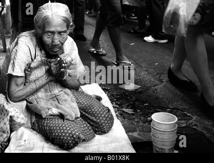 Thai dame mendie de l'argent dans un marché dans les rues de Bangkok en Thaïlande. Banque D'Images