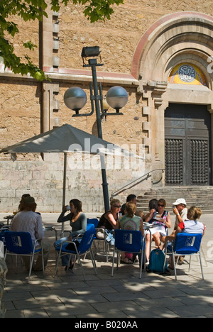 Les touristes et habitants de profiter de l'ombre d'un arbre par une chaude journée d'été à un café près de l'église de Saint Joan dans le Gracia de Barcelone, Espagne Banque D'Images