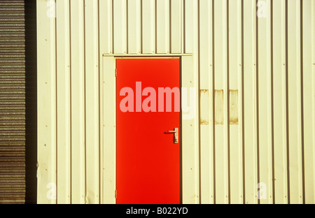 Détail à lumière chaude d'entrepôt ou d'atelier ou d'usine avec caillebotis rouge mur gris pâle et gris foncé porte en bois porte rouleau Banque D'Images