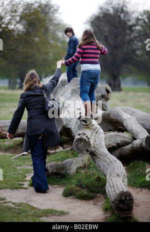 Petite famille jouant dans grand parc. Banque D'Images