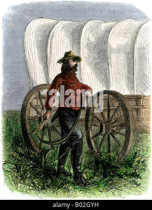 Bullwhacker à côté d'un wagon couvert sur le Santa Fe Trail. À la main, gravure sur bois Banque D'Images