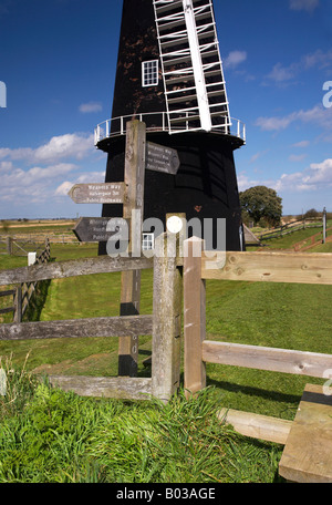 Sentier Public & stile sur les Norfolk Broads avec bras Berney moulin & voiles dans l'arrière-plan Banque D'Images