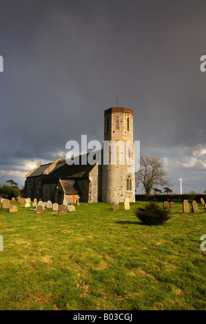 Église à Winterton sur mer avec les éoliennes modernes dans la distance sur un jour de tempête dans le Norfolk. Banque D'Images