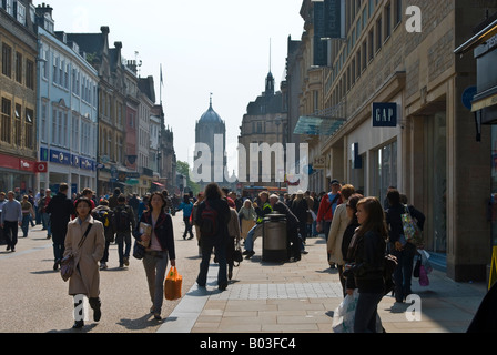 Dans Cornmarket Street Shopping, Oxford, Angleterre, avec Tom Tower du Christ Church College dans l'arrière-plan Banque D'Images