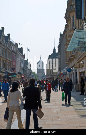 Dans Cornmarket Street Shopping, Oxford, Angleterre, avec Tom Tower du Christ Church College dans l'arrière-plan Banque D'Images