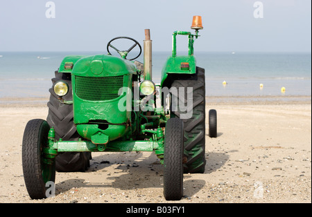 Vieux tracteur vert utilisé pour le remorquage de bateaux sur la plage à Donneville La Manche Normandie France Banque D'Images