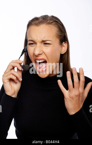 Angry Businesswoman Yelling Into Headset Banque D'Images
