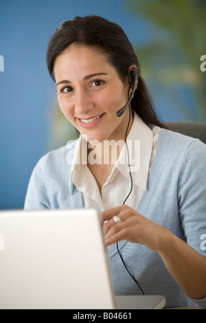 Femme avec casque et un ordinateur portable Banque D'Images