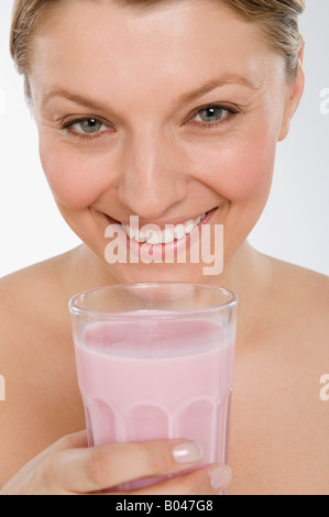 Une femme tenant un lait frappé aux fraises Banque D'Images