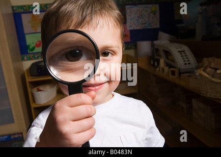 Boy holding a magnifying glass Banque D'Images