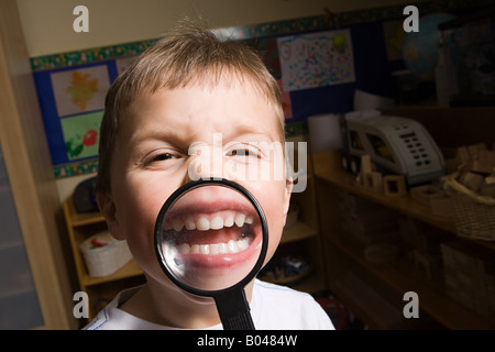 Boy holding a magnifying glass Banque D'Images