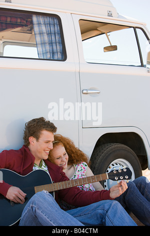 Un jeune homme tuning sa guitare Banque D'Images