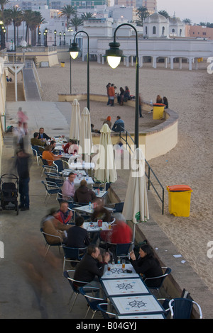 Café en plein air le long de la Playa de la Caleta (plage) après le coucher du soleil dans la ville de Cadix, Province de Cadiz, Costa de la Luz, Andalousie Banque D'Images