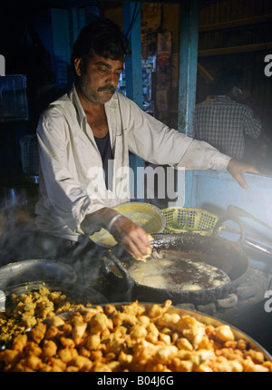 Vendeur de rue, rendant les aliments frits épicés Banque D'Images