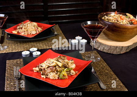 Délicieux bol en bois avec riz pilaf sur un paramètre de table rouge et noir Banque D'Images