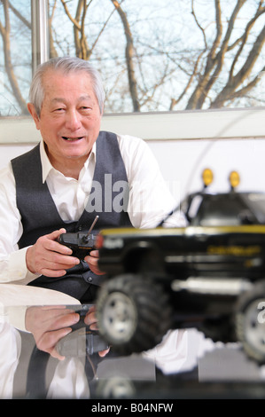Senior asian man having fun Playing with toy car Banque D'Images
