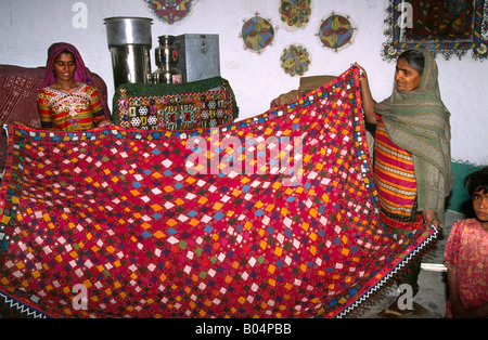 L'Inde Rann de Kutch Gujerat Banni salon Raisi Putra musulmanes holding couvre-lit brodé Banque D'Images