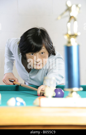 Femme asiatique d'âge moyen pratique billard Banque D'Images