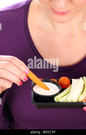 Young Woman Eating crudités avec une trempette Parution Modèle Banque D'Images