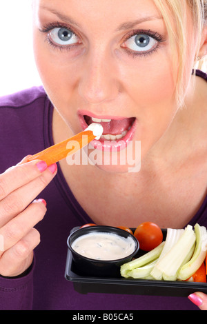Young Woman Eating crudités avec une trempette Parution Modèle Banque D'Images