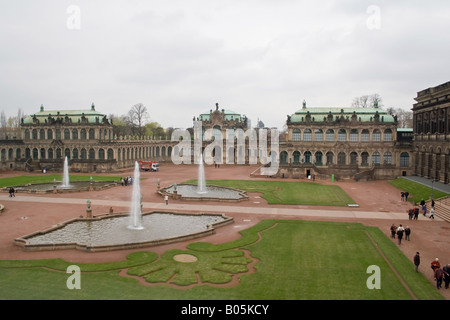 Le palais Zwinger à Dresde avec son architecture baroque, ses fontaines et ses jardins entretenus sous un ciel nuageux. Banque D'Images