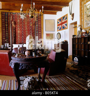 Chambre avec des fauteuils en cuir et d'étoffes à motifs wall hanging in South African Dutch Homestead Banque D'Images