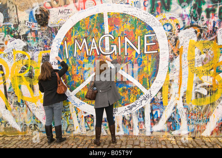 Grand angle horizontal de touristes de la rédaction d'un message sur le mur de la paix Lennon dans le moindre Trimestre 'Mala Strana'. Banque D'Images