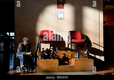 Un service de cireur vendeur attend les clients comme tôt le matin, la lumière brille à New Haven's Union Station. USA Banque D'Images