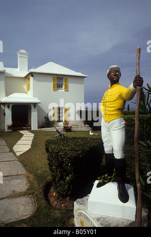 Statue de l'homme noir le port de gilet jaune, bouchon blanc, blanc et noir d'équitation bottes d'équitation à l'extérieur grande maison blanche à Hamilton, aux Bermudes Banque D'Images