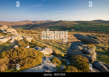 Affleurements de granite dans le parc national du Dartmoor à l'ensemble de Hound Tor Tor et de foin à l'horizon, Devon, Angleterre Banque D'Images