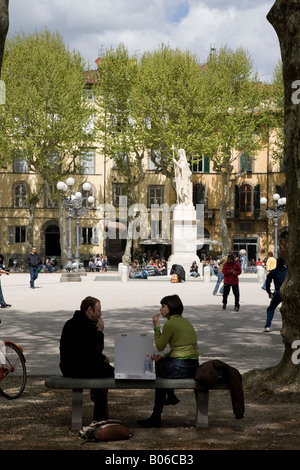 Un couple de manger le déjeuner sur la Piazza Napoleone Lucca Italie Banque D'Images