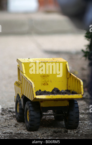 Camion benne jouet Tonka jaune transporte la saleté Banque D'Images