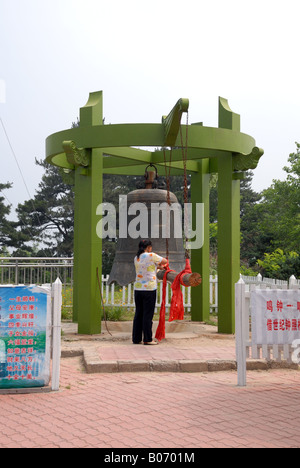 Femme décorant la gâche en bois d'un grand bell avec un red sash Jigong Jigong Shan Mountain National Park Mountain Jigong Banque D'Images