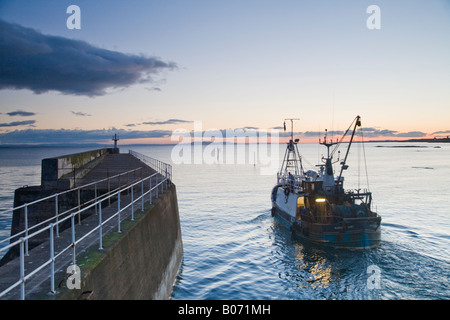 Pitteweem Harbour au crépuscule avec chalutier de pêche vers la mer Banque D'Images