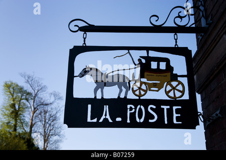 Un bureau de poste français signe pendaison dans Jumièges Normandie France, une silhouette contre un ciel bleu. Banque D'Images