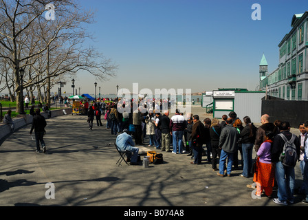 Les touristes en attente dans la ligne pour la visite de Liberty Island pour voir la Statue de la liberté, New York Banque D'Images