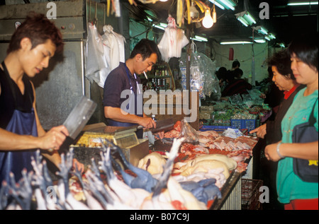 Les hommes du dépeçage et de la vente de poulet sur le marché traditionnel de la Chine de Taiwan Banque D'Images