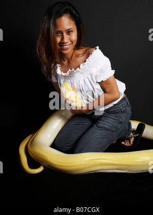 Femme avec un énorme python albinos autour d'elle Banque D'Images