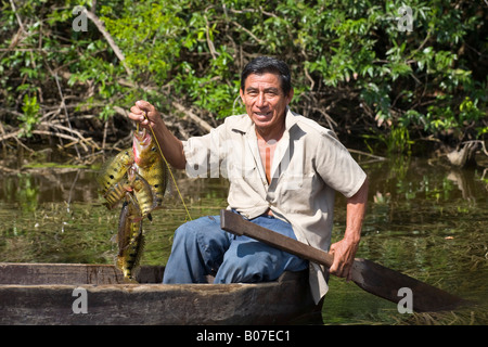 Belize, Lamanai, New River, pêcheur en canot creusé brandissant une Siglet géant Banque D'Images
