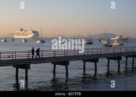 Panama, Panama City, promeneurs sur jetée avec un bateau de croisière naviguant dans le canal de Panama Banque D'Images