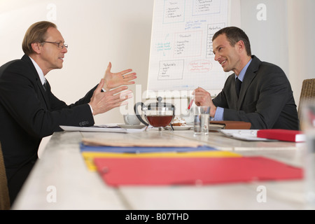 Deux hommes assis sur une table de négociation Banque D'Images