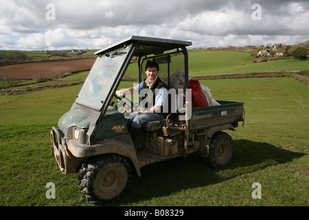 Un portrait d'un jeune agriculteur dans le nord du Devon se tenait près de son véhicule agricole Banque D'Images