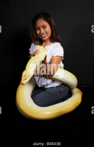 Femme entourée par d'immenses Python albinos Banque D'Images