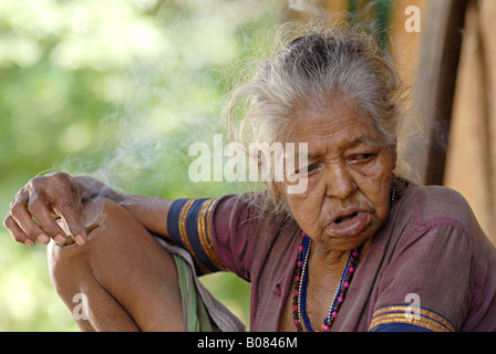 Vieille Femme fumant bidi, une cigarette à la main indienne faite de feuilles de tabac ou beedi. Tribu Warli Banque D'Images