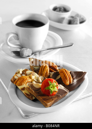 Des carrés de chocolat au lait de noix et de fraise avec une machine à expresso Banque D'Images