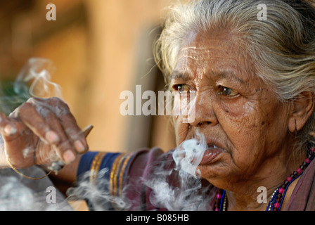 Libre d'une vieille femme fumant bidi, une cigarette à la main indienne faite de feuilles de tabac ou beedi. Tribu Warli Banque D'Images