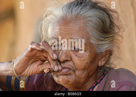 Libre d'une vieille femme fumant bidi, une cigarette à la main indienne faite de feuilles de tabac ou beedi. Tribu Warli, Thane, Inde Banque D'Images