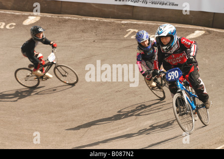 Jeune garçon enfant vélo BMX rider en compétition de sport de niveau national sur le virage relevé bend au cours de BMX Cheddar Angleterre Somerset Banque D'Images